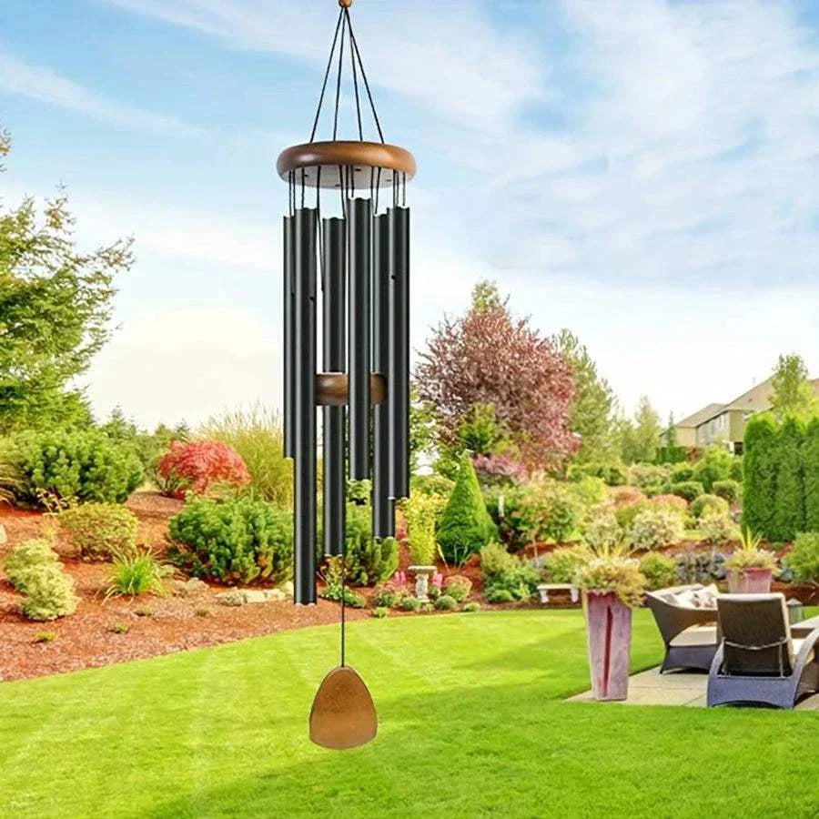 Classic black aluminum wind chimes with wooden tag hanging outdoors in garden setting